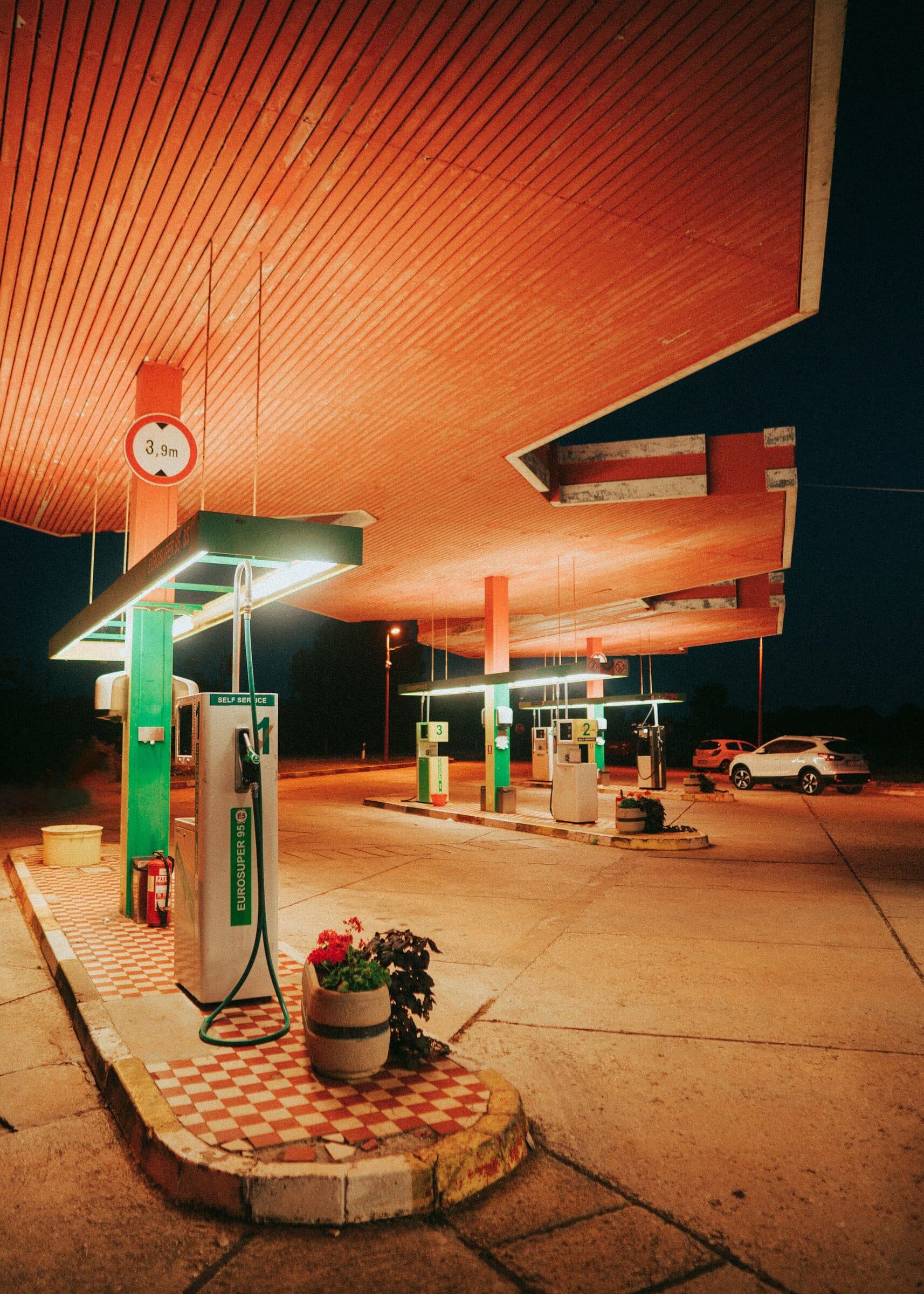 A retro gas station canopy glowing warm orange at night.