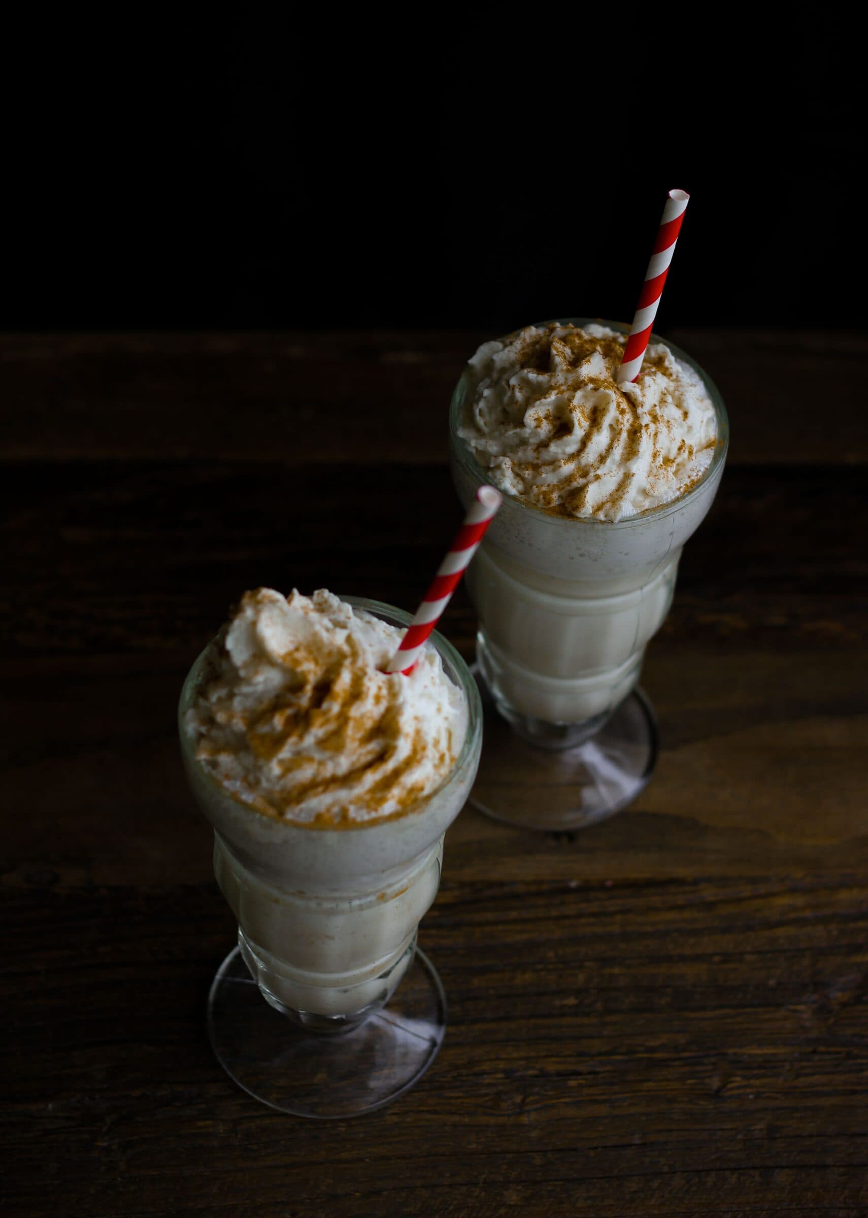 Two blended iced coffees topped with whipped cream and caramel.