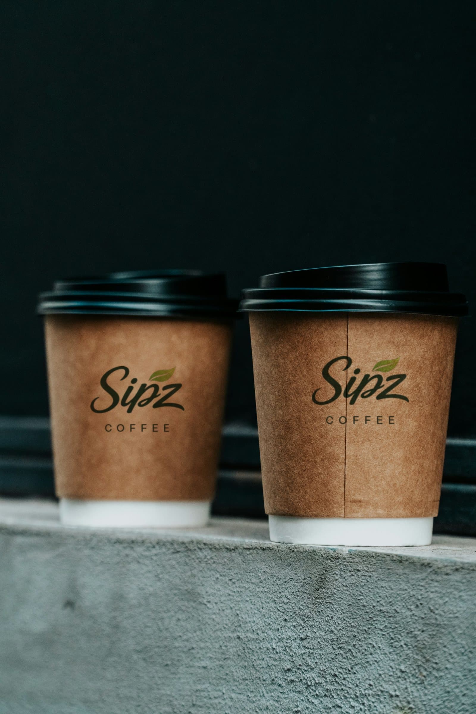 Two SIPZ coffees side by side on a concrete ledge.
